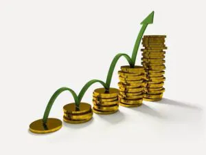 Business Graph With Arrow And Coins Showing Profits And Gains